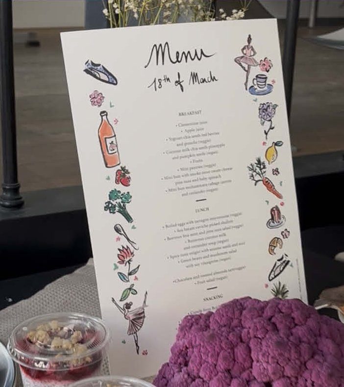 Menu illustré à l’aquarelle posé sur une table de réception — option papeterie illustrée