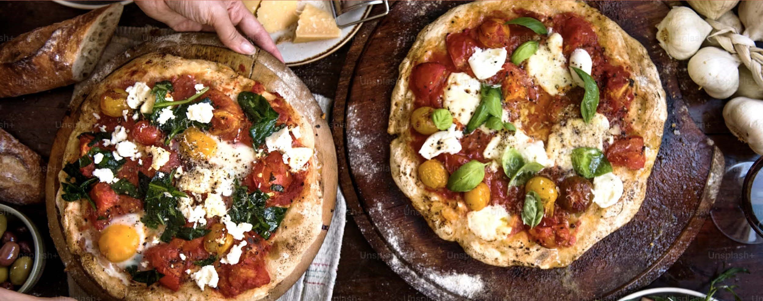 Deux pizzas maison aux tomates cerises, mozzarella et basilic sur des planches en bois — Toscanacci a casa, pizzas à domicile